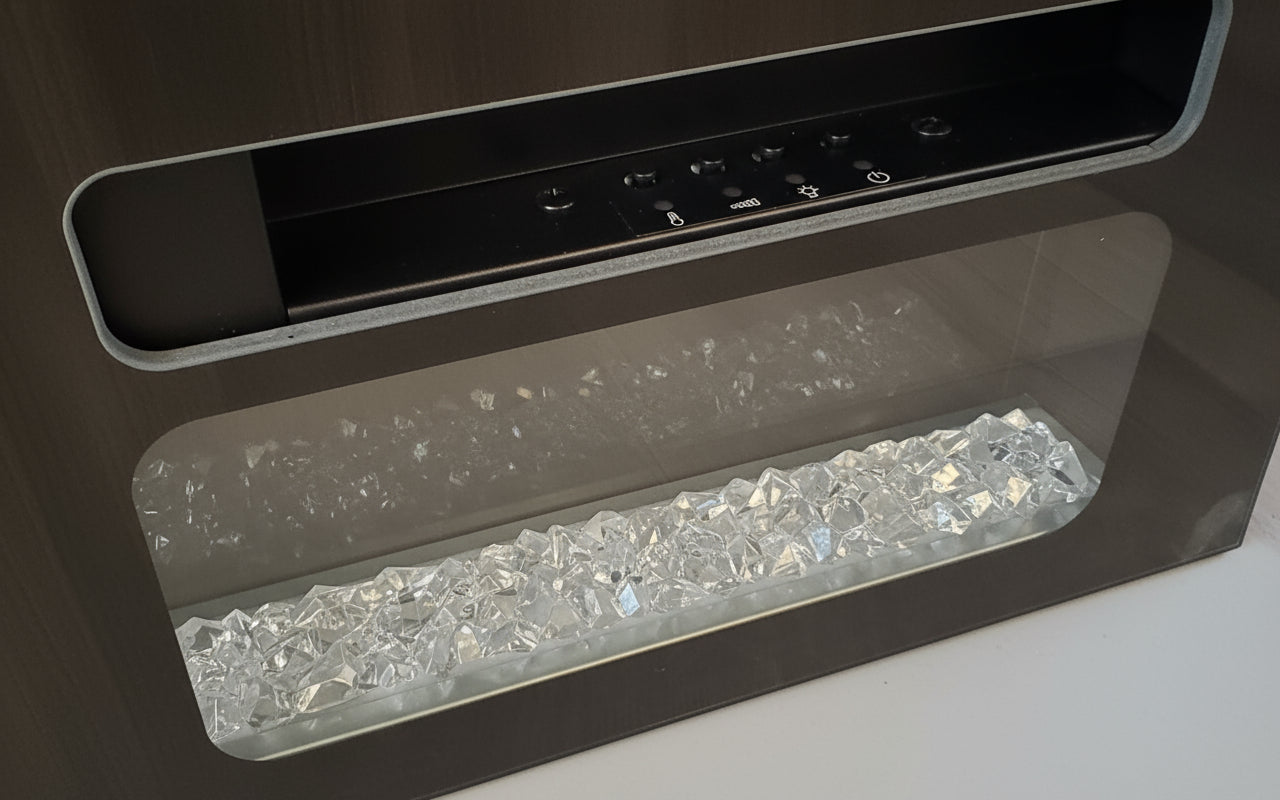 Close-up of a modern fireplace with glass beads and control panel.
